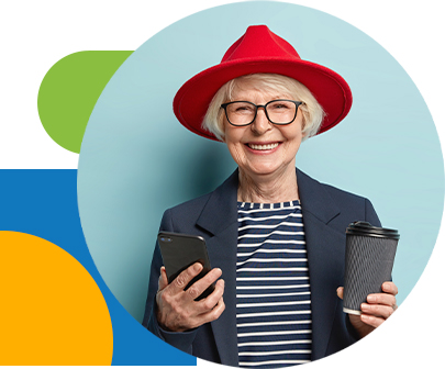 positive-beautiful-red-haired-woman-in-glasses-uses-cell-phone-sends-message-via-multimedia-application-surfes-social-networks-has-coffee-break-holds-disposable-cup-of-beverage-isolated-on-blue